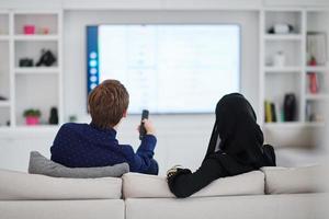 jeune couple musulman devant la télé ensemble photo