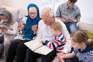 grands-parents musulmans modernes avec petits-enfants lisant le coran photo