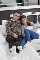 jeune couple détendu devant la télé à la maison photo