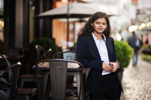 magnifique femme indienne porter une pose formelle dans la rue avec un téléphone portable à portée de main. photo