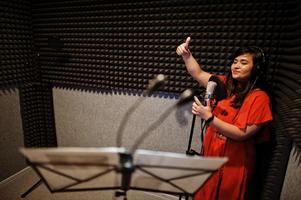 jeunes chanteurs asiatiques en duo avec microphone enregistrant une chanson dans un studio de musique d'enregistrement. photo