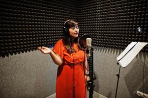 jeune chanteuse asiatique avec microphone enregistrant une chanson dans un studio de musique d'enregistrement. photo