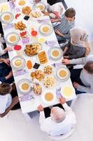 vue de dessus de la famille musulmane multiethnique moderne attendant le début du dîner de l'iftar photo