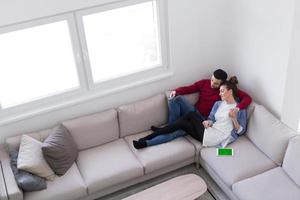 jeune couple sur le canapé devant la télévision photo