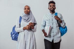 jeune couple d'étudiants africains marchant femme portant le hijab musulman traditionnel du soudan équipe commerciale isolée sur fond blanc. photo de haute qualité