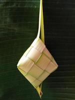 isolé. le ketupat vide n'a pas été rempli de riz. en indonésie, il apparaît souvent avant la célébration de l'aïd al-fitr après le ramadan. concept de design, fond vert foncé. photo
