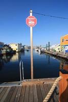 un panneau d'arrêt de ferry sur un quai entre les maisons flottantes. photo