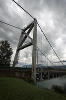 un pont suspendu enjambant une rivière dans les montagnes. photo