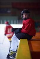 Enfants joueurs de hockey sur glace sur banc photo