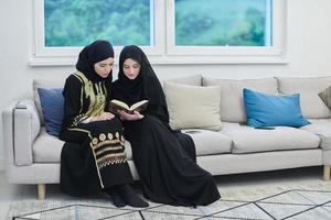 portrait de jeunes femmes musulmanes lisant le coran dans une maison moderne. photo