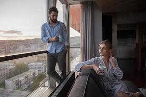 jeune couple appréciant le café du soir près de la fenêtre photo