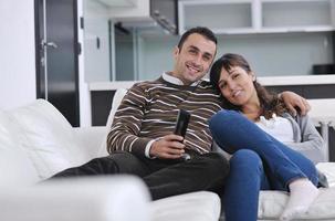 jeune couple détendu devant la télé à la maison photo