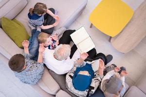 vue de dessus des grands-parents musulmans modernes avec des petits-enfants lisant le coran photo