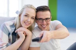 jeune couple sur le canapé devant la télévision photo