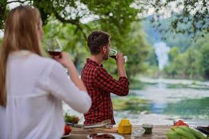 amis portant un verre de vin rouge tout en pique-nique dîner français photo