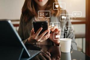 médias sociaux et marketing concept d'écran d'icônes virtuelles. gros plan d'une femme d'affaires tapant clavier tablette avec ordinateur portable et téléphone intelligent photo
