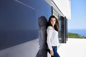 femme détendue devant une maison moderne de luxe photo