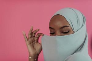 portrait de jeune beauté musulmane moderne portant des vêtements islamiques traditionnels sur fond rose en plastique. mise au point sélective photo