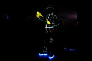 barman professionnel et spectacle de lumière led. silhouette de barman moderne secouant la boisson au bar à cocktails de nuit. photo