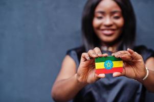 une femme africaine tient un petit drapeau éthiopien dans les mains. photo