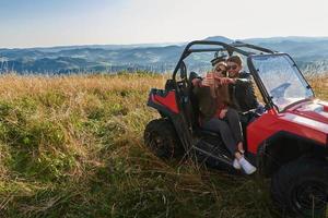 couple profitant d'une belle journée ensoleillée prenant une photo de selfie tout en conduisant un buggy hors route