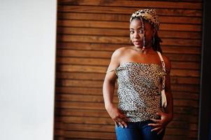 belle femme afro-américaine avec des dreadlocks en tenue de léopard au café. belle jeune fille noire à la mode cool à l'intérieur. photo