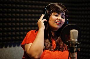 jeune chanteuse asiatique avec microphone enregistrant une chanson dans un studio de musique d'enregistrement. photo