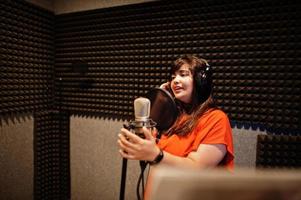 jeune chanteuse asiatique avec microphone enregistrant une chanson dans un studio de musique d'enregistrement. photo