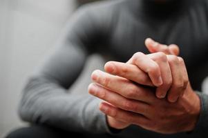 gros plan sur les mains d'un homme élégant portant un col roulé gris. photo