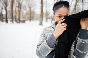 femme africaine portant une écharpe noire pose en journée d'hiver en europe. photo