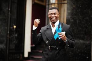 un homme afro-américain tient un ruban bleu de la prostate. sensibilisation au cancer de la santé des hommes. photo