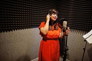 jeune chanteuse asiatique avec microphone enregistrant une chanson dans un studio de musique d'enregistrement. photo