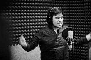 jeune chanteur asiatique avec microphone enregistrant une chanson dans un studio de musique d'enregistrement. photo