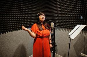 jeune chanteuse asiatique avec microphone enregistrant une chanson dans un studio de musique d'enregistrement. photo