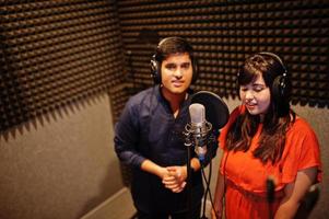 jeunes chanteurs asiatiques en duo avec microphone enregistrant une chanson dans un studio de musique d'enregistrement. photo