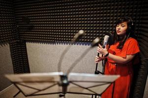 jeunes chanteurs asiatiques en duo avec microphone enregistrant une chanson dans un studio de musique d'enregistrement. photo