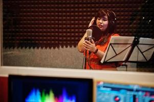 jeune chanteuse asiatique avec microphone enregistrant une chanson dans un studio de musique d'enregistrement. photo