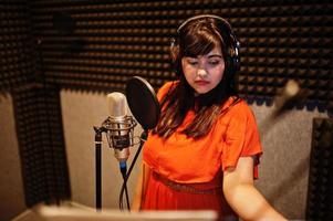 jeune chanteuse asiatique avec microphone enregistrant une chanson dans un studio de musique d'enregistrement. photo