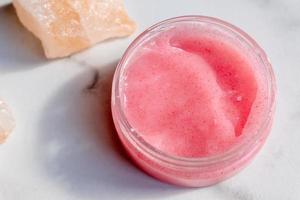 sel de l'himalaya et gommage rose pour le corps ou le visage sur fond de marbre. sel de bain. traitement de Spa. concept de beauté et de détente. photo