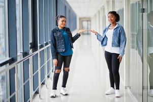deux amies africaines en veste de jeans montrent les mains à l'intérieur ensemble. photo