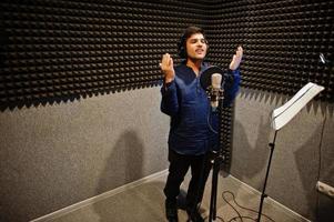 jeune chanteur asiatique avec microphone enregistrant une chanson dans un studio de musique d'enregistrement. photo