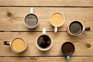 de nombreuses tasses avec un café aromatique savoureux sur une table en bois. vue de dessus avec espace de copie photo