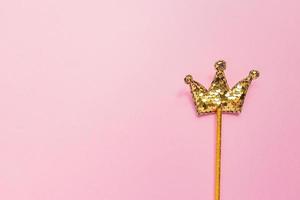bâton magique doré de paillettes en forme de couronne sur fond rose pastel. mise à plat créative dans un style minimal. copier l'espace pour le texte photo