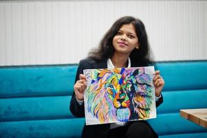 une artiste indienne porte une image de peinture formelle, assise au café. photo