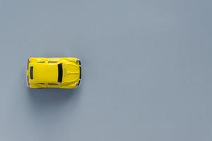 mise à plat dans un nouveau coloris tendance 2021. jaune éclairant et gris ultime. couleur de l'année 2021. voiture jouet rétro sur fond gris avec copie sapce photo