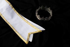 ceinture gagnante en or blanc pour le concours de beauté miss pageant, zone vide pour le mot gagnant du texte du pays, éclairage de studio arrière-plan textile drapé sombre abstrait, décoration d'importance avec couronne de diamant photo