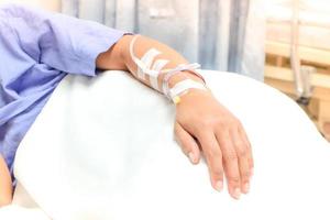 gros plan sur une goutte de solution saline dans la main du patient. femme asiatique hospitalisée. photo