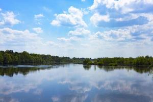 large fleuve aux côtes vertes et ciel avec nuages photo