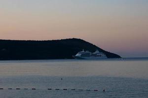 baie de kotor, monténégro - 21 octobre 2020 - bateau de croisière seabourn sdyssey dans la baie de kotor. l'ensemble du navire est visible de derrière. falaises rocheuses et ciel bleu. photo