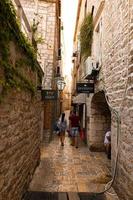 budva, monténégro - 20 octobre 2020 - fragment de la vieille ville, vieilles maisons avec touristes à pied, rue très étroite, cafés, boutiques. photo